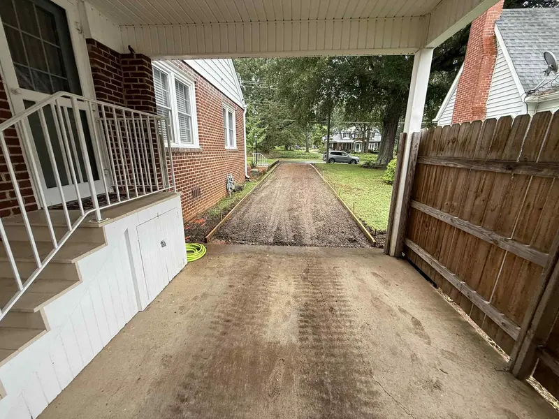 Cracked and broken driveway removed down to bare soil between two houses