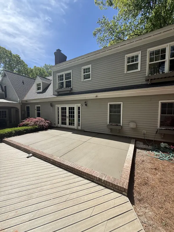 New concrete patio with brick soldier-course border off a set of french doors