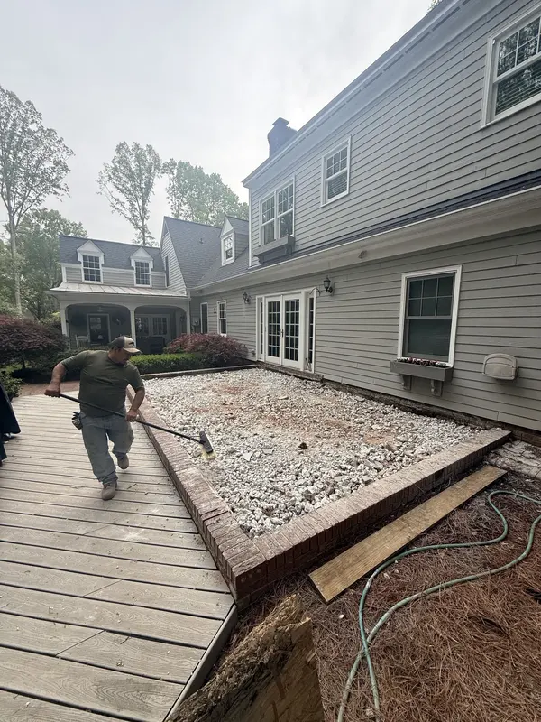 Old patio surface removed beside a gray colonial home